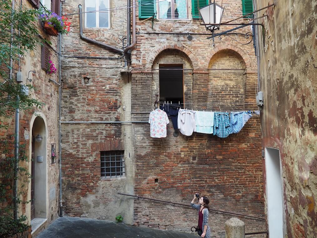 Woman photographing clothes hanging out to dry