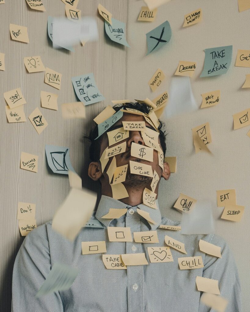 Man covered in post it notes with things for post about how to manage stress and live a peaceful life