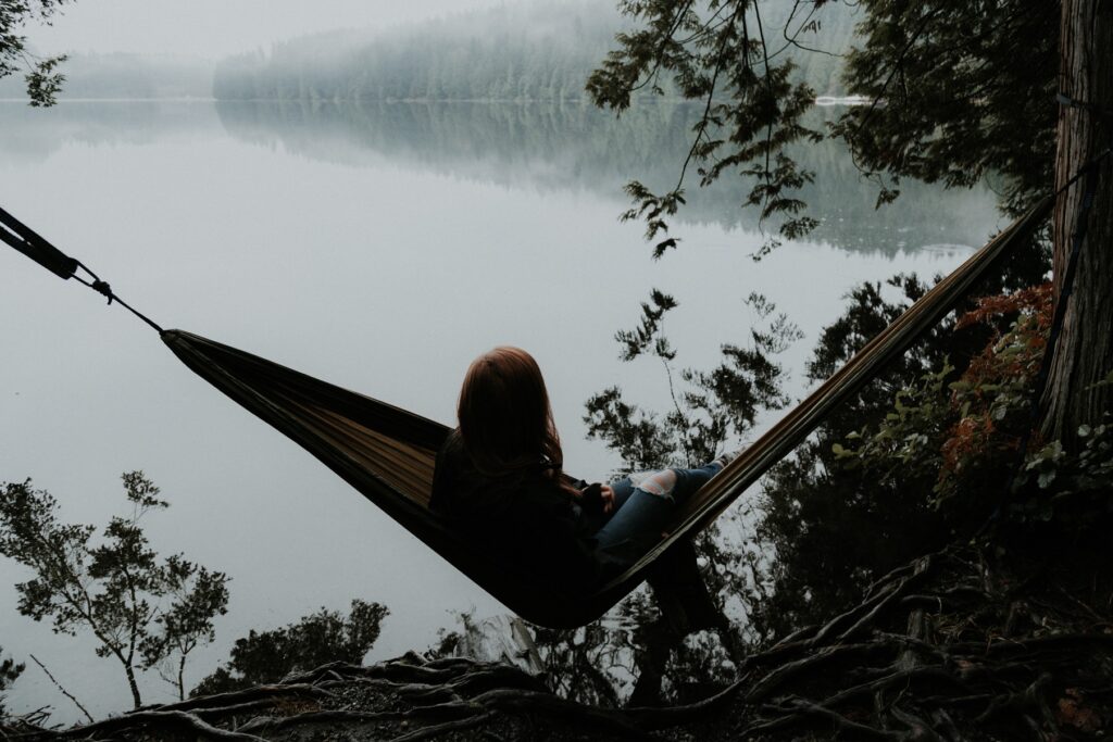 Woman sitting on hammock for rest and for blog post on manage stress and live a peaceful life