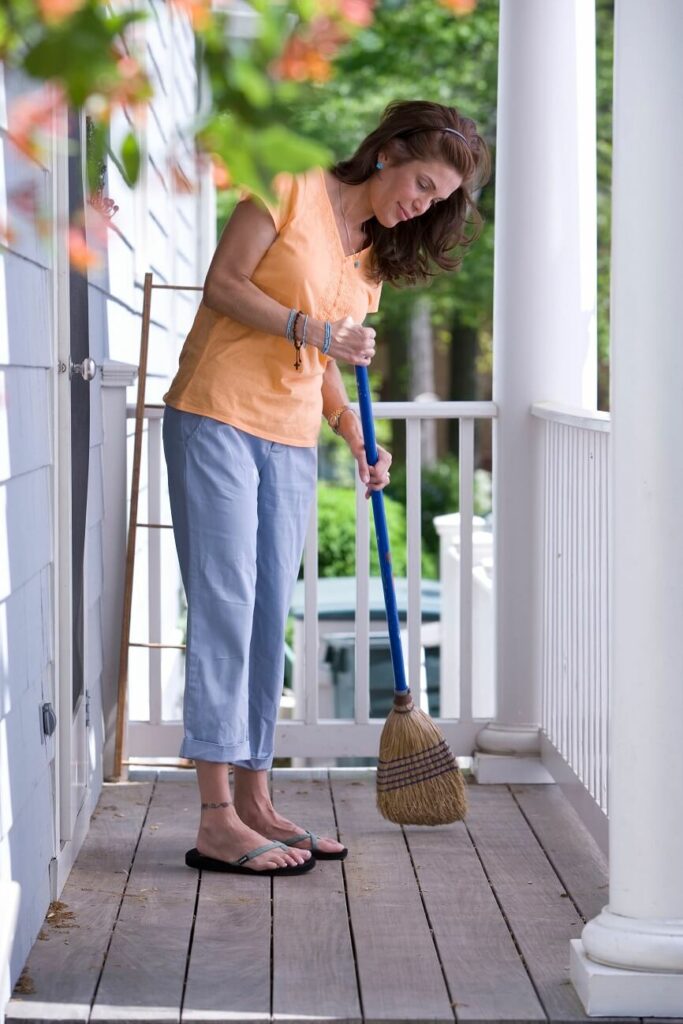 woman sweeping the porch showing the benefits of exercise